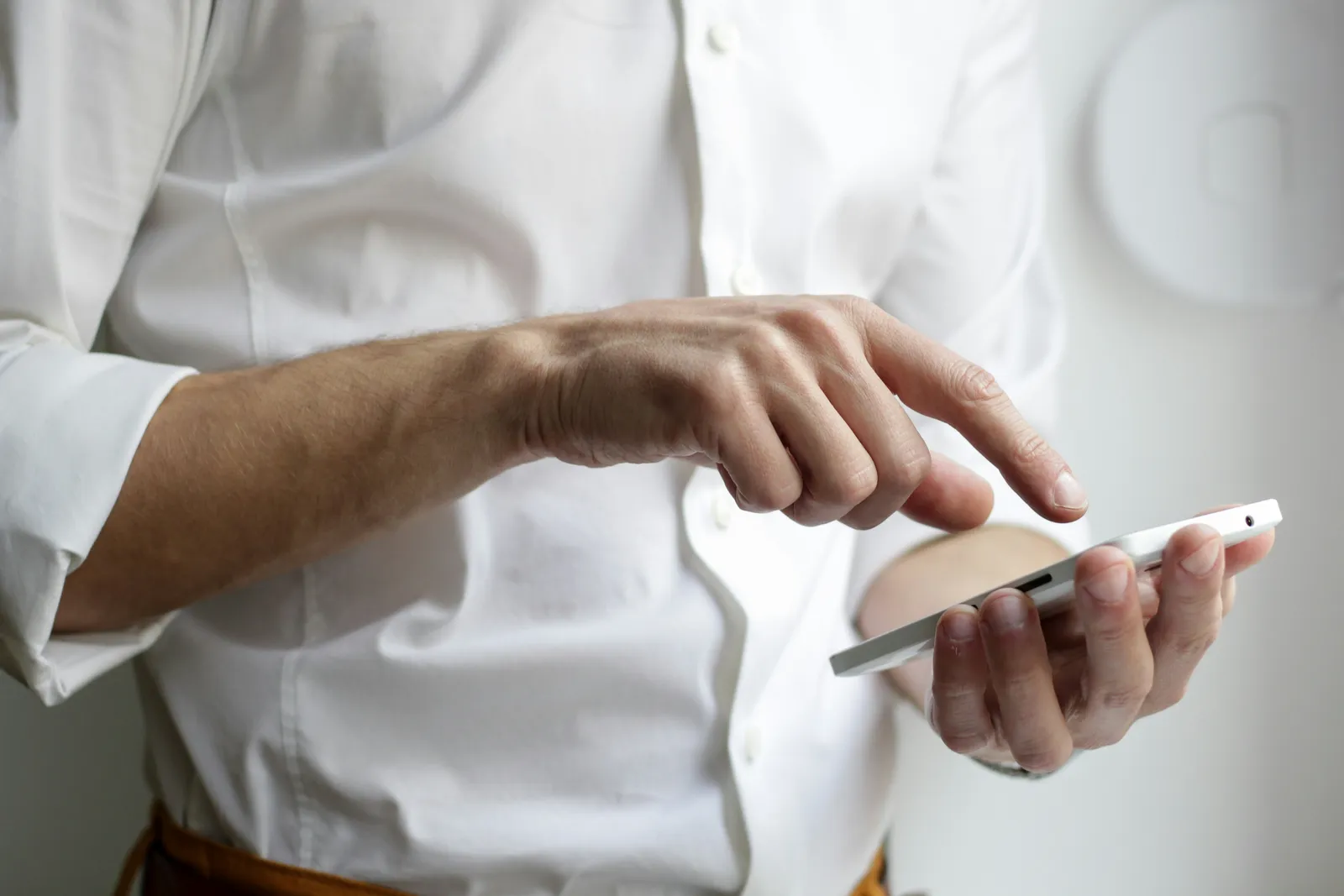 person holding white Android smartphone in white shirt Android phone checking the Android 17 QPR1 update status